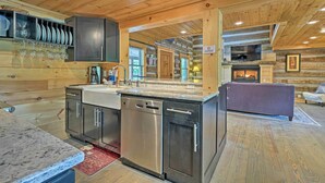 Eine moderne Küche mit Granit Arbeitsplatten, Edelstahlgeräten und Holzschränken.