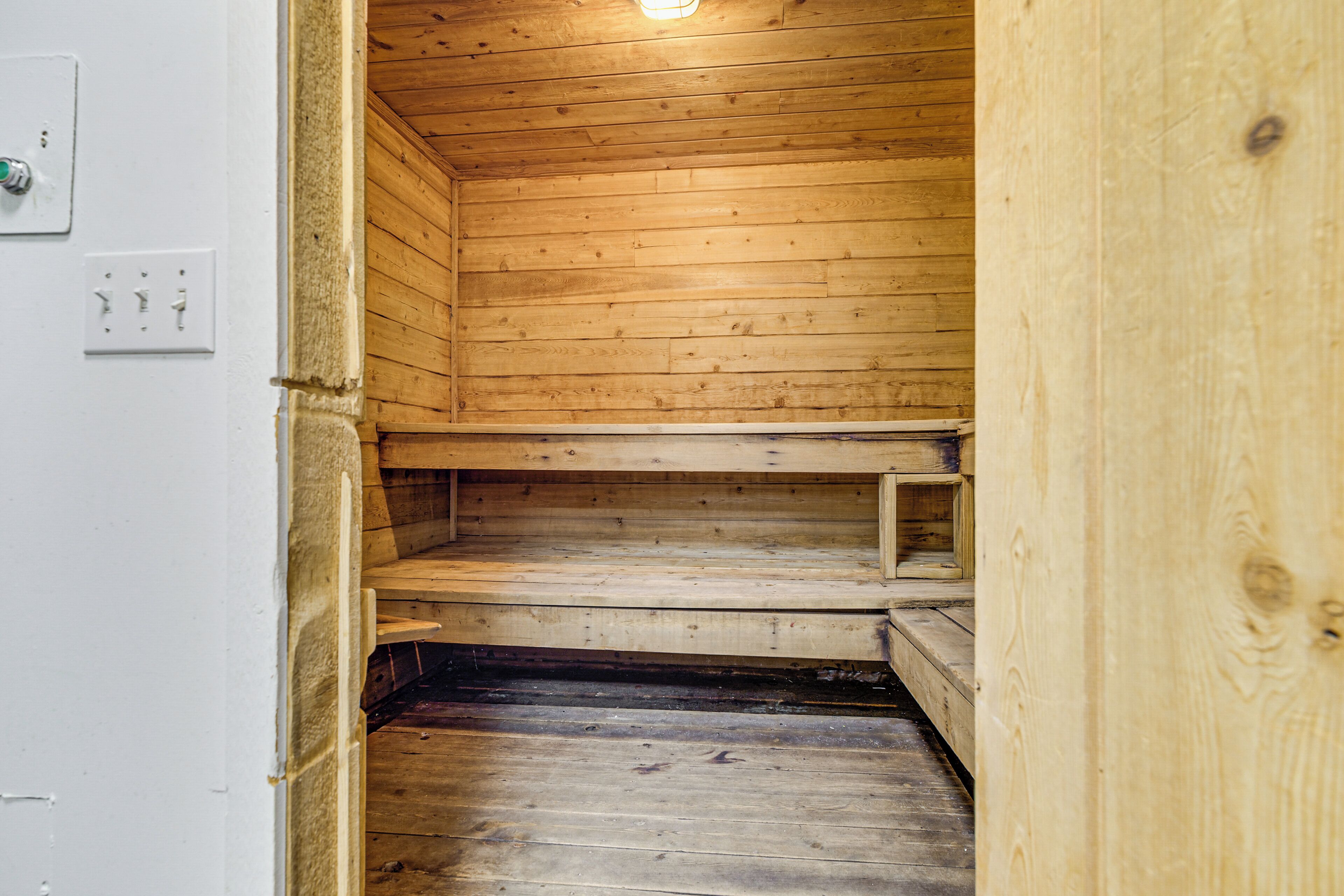 A wooden sauna with benches and a sloped ceiling.