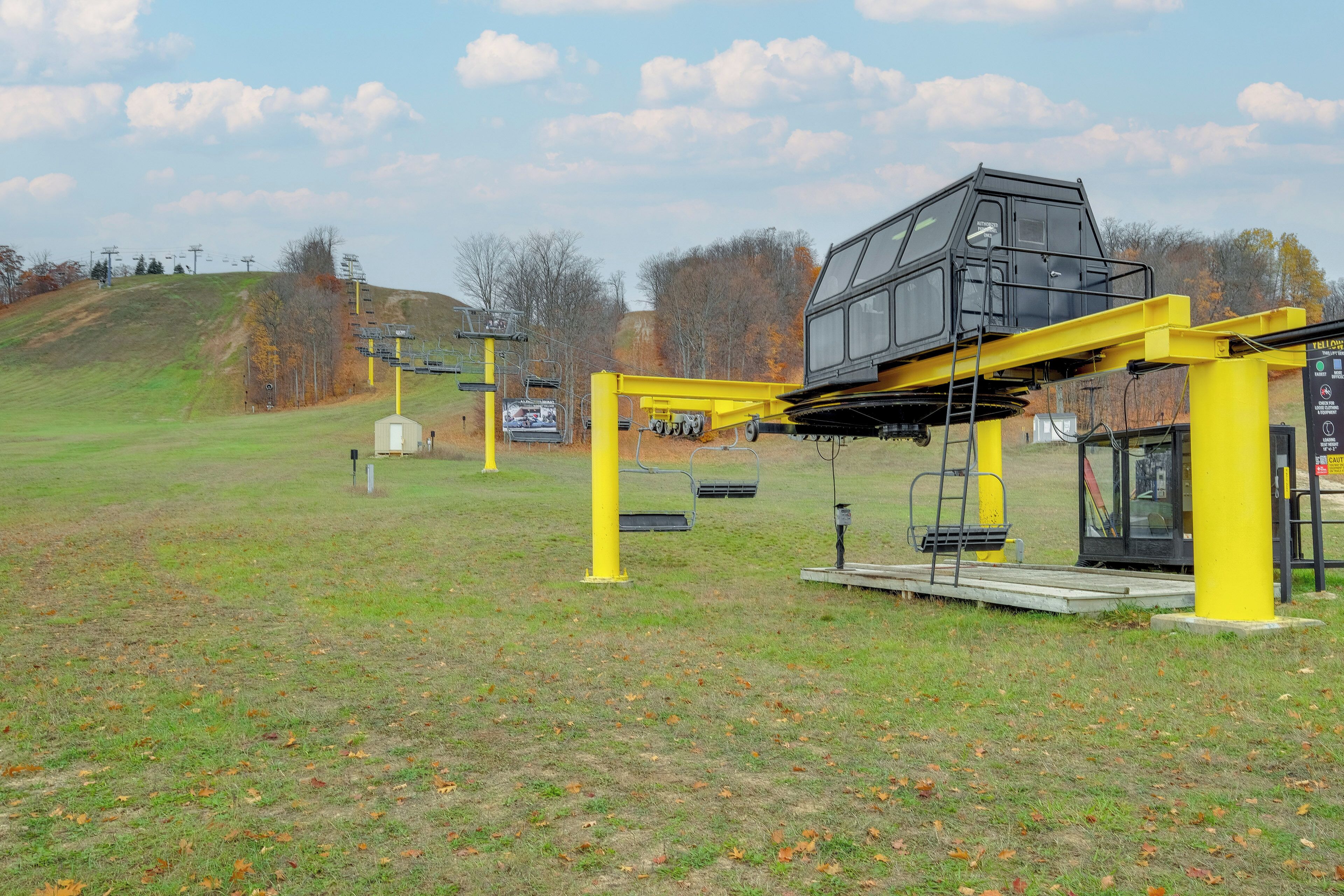 A ski lift system with yellow supports and a cabin.