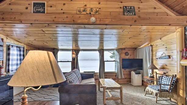 A cabin interior with a sofa, a table, a rocking chair, and a television. - Charming Lost Lake Cabin: Fish, Boat & Hunt! (St Germain)
