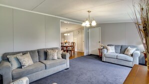 A living room with two grey sofas, a wooden coffee table, and a dining area with a table and chairs. - 1 Mi to US Marine Base Albany: Cozy Getaway! (Albany)
