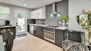 Una cocina moderna con electrodomésticos de acero inoxidable, horno empotrado y un amplio ventanal.