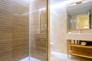 A modern bathroom with a glass shower enclosure, a wooden vanity, and a large mirror above the sink. - Luminous 1 Bedroom Apartment in the Heart of Seville. Murillo V (Seville)