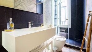 A modern bathroom with a large white sink, a glass shower enclosure, and a wooden ladder. - Bright Apartment in Sevilla Center. Murillo VI (Seville)