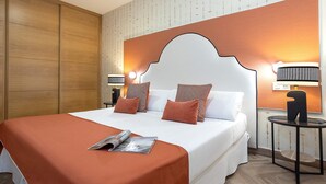 A hotel room with a large bed, a wooden wardrobe, and two bedside lamps. - Bright Apartment in Sevilla Center. Murillo VI (Seville)