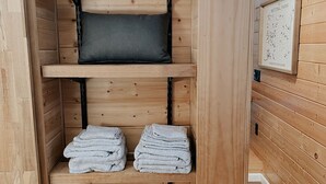 A wooden sauna with shelves for towels and a framed map on the wall. - Cozy cabin on Lookout Mountain (Lookout Mountain)