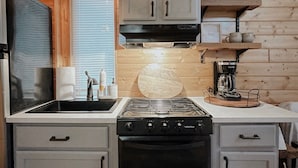 A kitchen with a stove, oven, microwave, and a coffee maker on a countertop. - Cozy cabin on Lookout Mountain (Lookout Mountain)