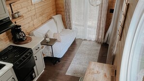 A compact cabin with a kitchenette, a sofa, and a large window. - Cozy cabin on Lookout Mountain (Lookout Mountain)
