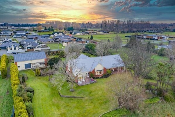 An aerial view of a residential area with houses, lawns, and trees.