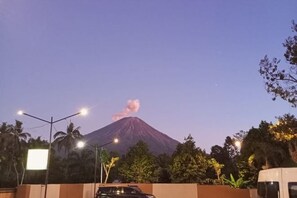 A mountain with a visible plume of smoke at dusk. - KALININGRAT COTTAGE 2 (Pronojiwo)