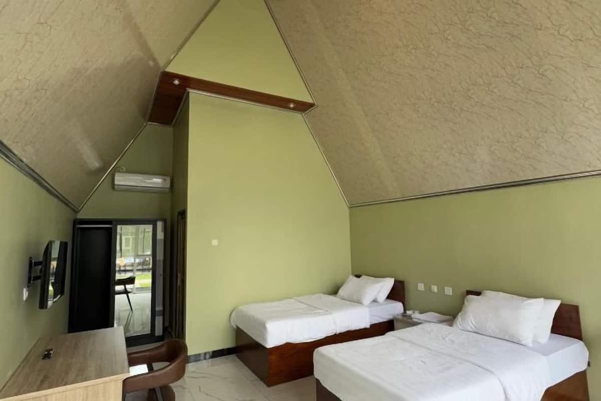 A room with two beds, a desk, and a chair.