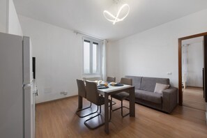 Une cuisine moderne avec une table à manger, des chaises et un réfrigérateur.