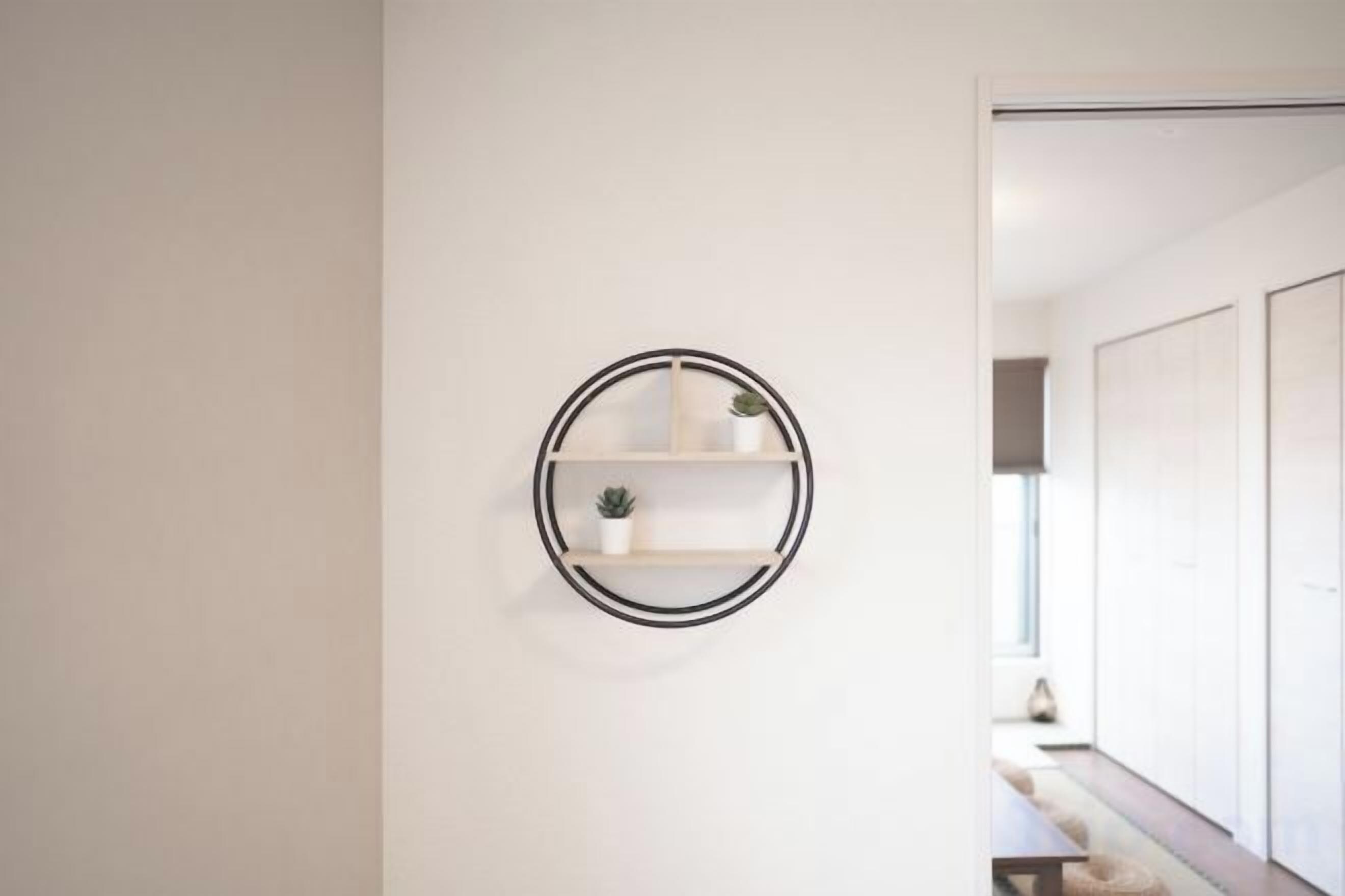 Une étagère murale minimaliste, ornée de deux plantes en pot.