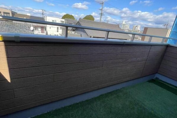 A corner of a room with a wooden wall and a metal railing.