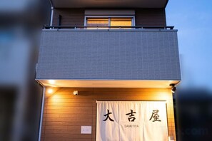 A building with a sign that reads 'DAIKITYA' and a banner with Japanese characters.