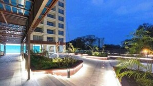 A modern building with a covered walkway and landscaped areas.