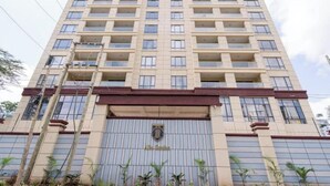A tall, beige-colored building with multiple balconies and a large entrance gate. - Deluxe Haven Kilimani with pool & gym yaya center (Nairobi)