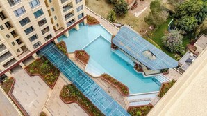 A rooftop pool area with multiple swimming pools and a glass-enclosed structure. - Deluxe Haven Kilimani with pool & gym yaya center (Nairobi)