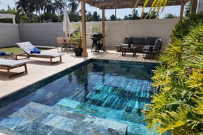 A clear swimming pool with lounge chairs and a barbecue area. - Beach House |Private Pool |Parking (Las Terrenas)