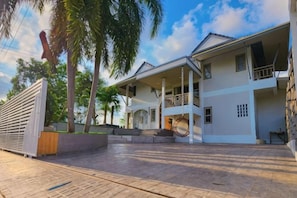 A two-story house with a covered porch, a staircase leading to the upper floor, and a gated entrance. - Sova Vcay Pool Villa (Ban Chang)