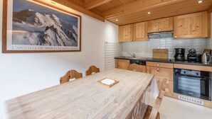Eine moderne Küche mit Holzausstattung, einer Edelstahl-Spüle und einem Bosch-Backofen.