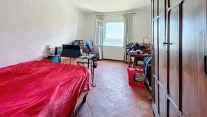 A room with a bed, a desk, a chair, a window with curtains, and a wardrobe. - Charming house with terrace and breathtaking views (Bages)