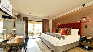 A modern hotel room with a large bed, a desk with a computer, and a view of the outdoors. - Kgarebana Boutique Guesthouse (Sesakhile)