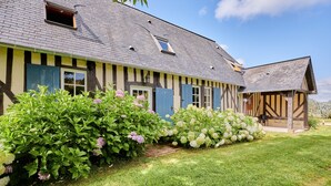 A traditional half-timbered house with a well-maintained garden and a small attached structure.