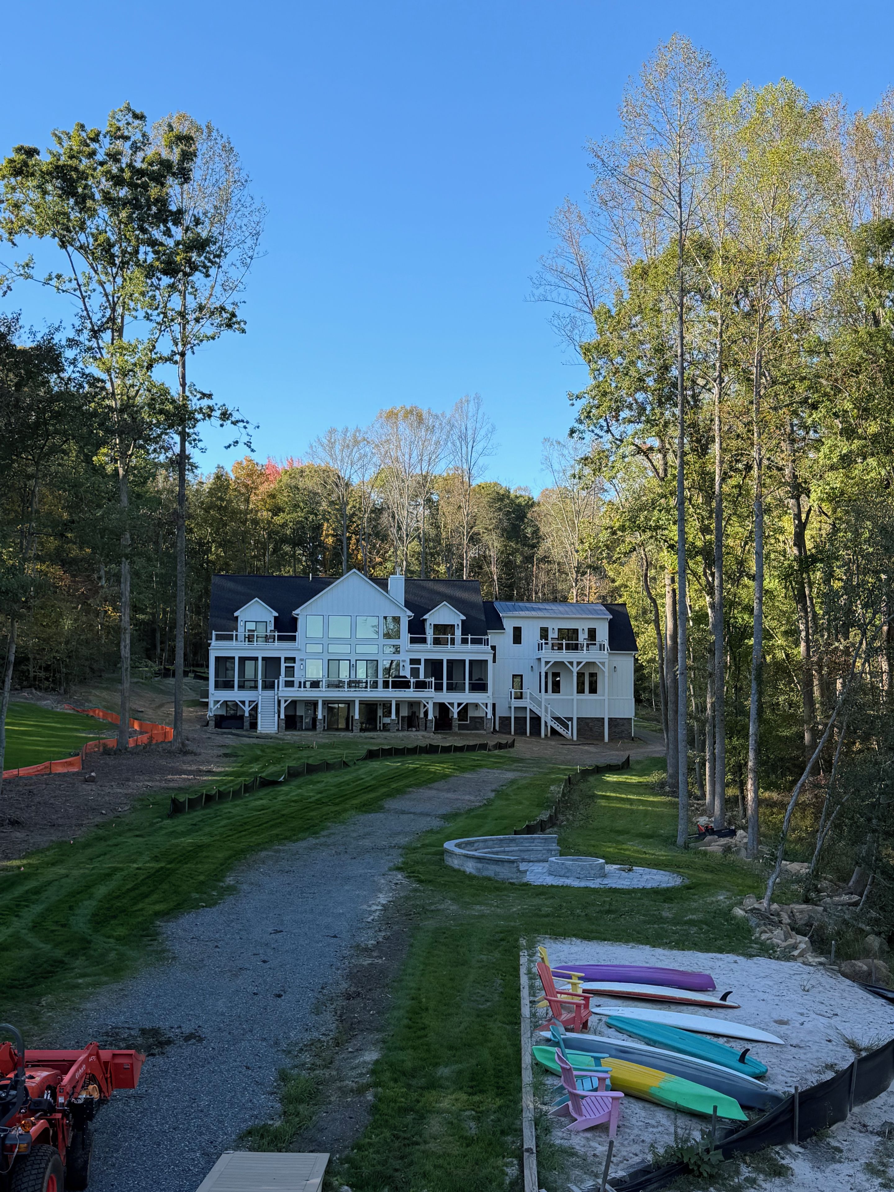 A large white building with multiple decks and a gravel path leading to it.