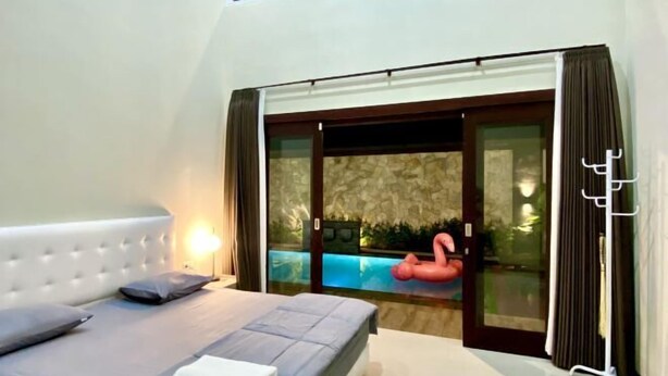 Une chambre avec un lit, une fenêtre et une vue sur une piscine extérieure.