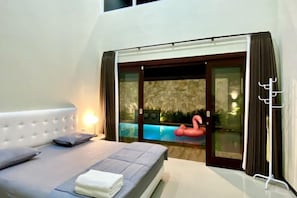 Quarto com cama, janela e vista para uma piscina ao ar livre.