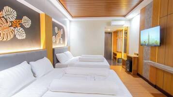 Quarto de hotel com design moderno, com uma cama grande, televisão e uma parede decorativa com padrões de folhas.