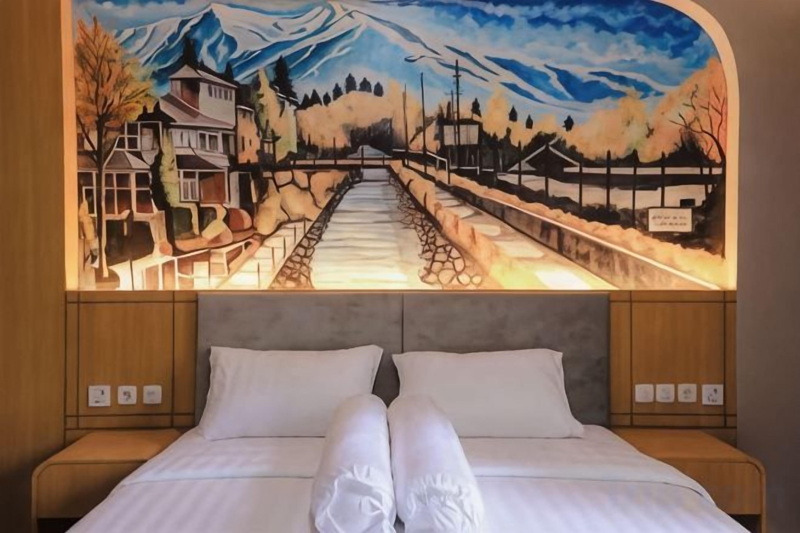 Una cama con ropa blanca y un cabecero con un mural de paisaje montañoso.
