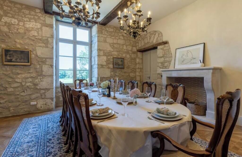 Ein Esszimmer mit Steinwand, Kamin und einer Chandelierleuchtre.