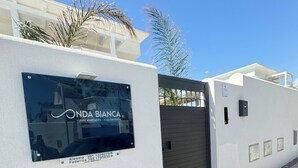 A luxury apartment building named 'ONDA BIANCA' with a modern design, a gated entrance, and a clear sky. - ONDA BIANCA LUXURY APARTMENTS (Realmonte)