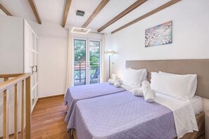 Un dormitorio con dos camas, un balcón y un cuadro en la pared.