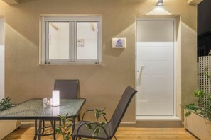 Una habitación con una mesa, sillas, un ventanal y una puerta.