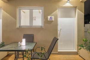 Una habitación con una mesa, sillas, un ventanal y una puerta.