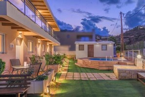 Un espacio exterior moderno con piscina, mobiliario y un césped bien cuidado.