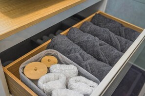 A drawer with neatly folded towels and a small wooden container. - BlueGreen Holiday Homes: Holidays with Seaview (Malevizi)