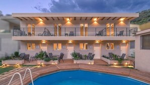 A two-story building with a swimming pool and outdoor seating. - BlueGreen Holiday Homes: Holidays with Seaview (Malevizi)