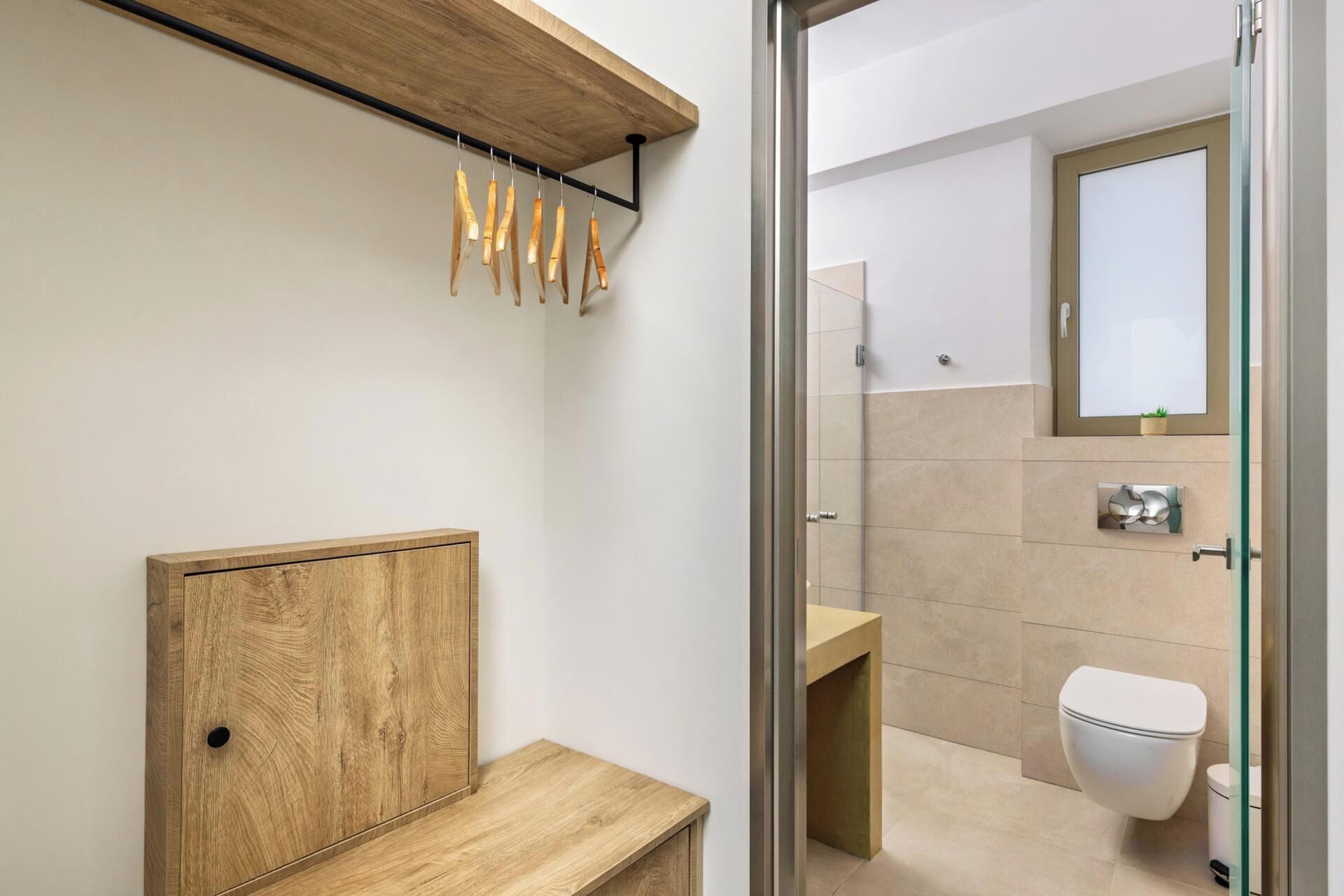 Un baño moderno con tocador de madera, cabina de ducha de vidrio y un inodoro.