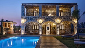 A two-story stone house with a swimming pool, outdoor seating, and a covered patio area. - Casa Di Pietra - Four Bedroom Villa, Sleeps 8 (Zakynthos)
