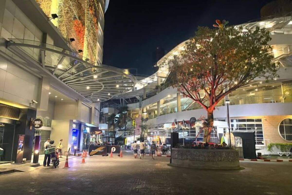 An indoor atrium with a central tree, multiple levels of shops, and a modern architectural design.