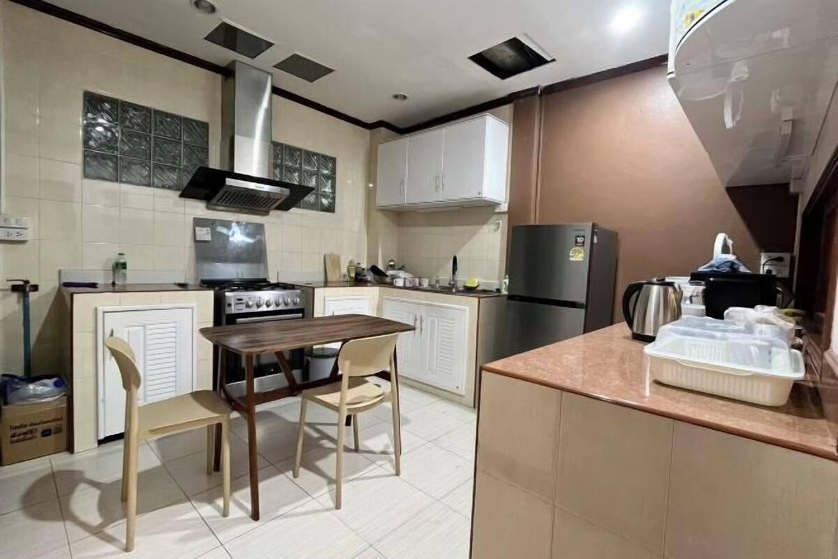 A compact kitchen with a central island, a stove, and a refrigerator.