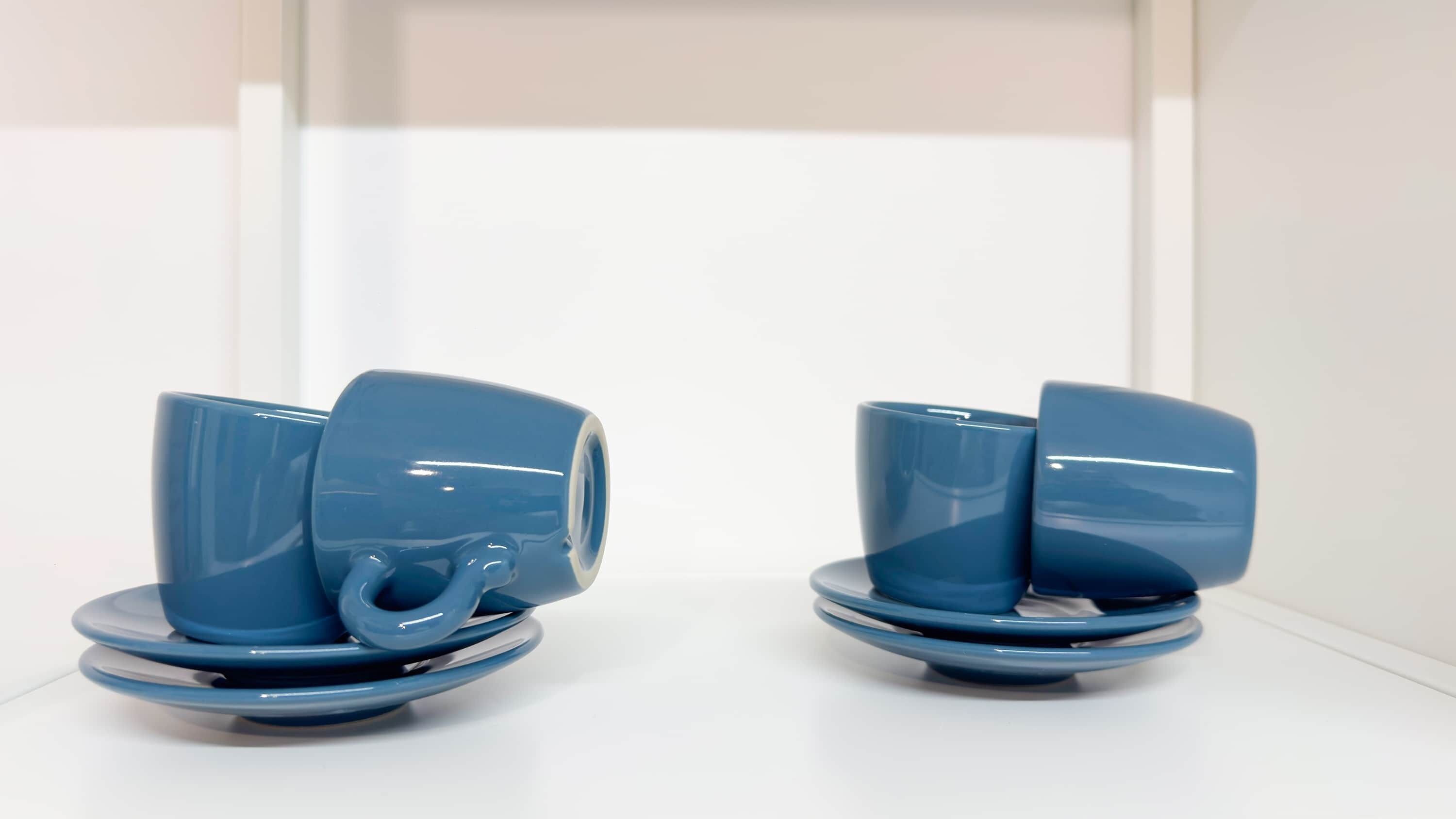 Two blue ceramic cups on saucers.