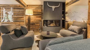 A cozy living room with a fireplace, wooden walls, and modern furniture.