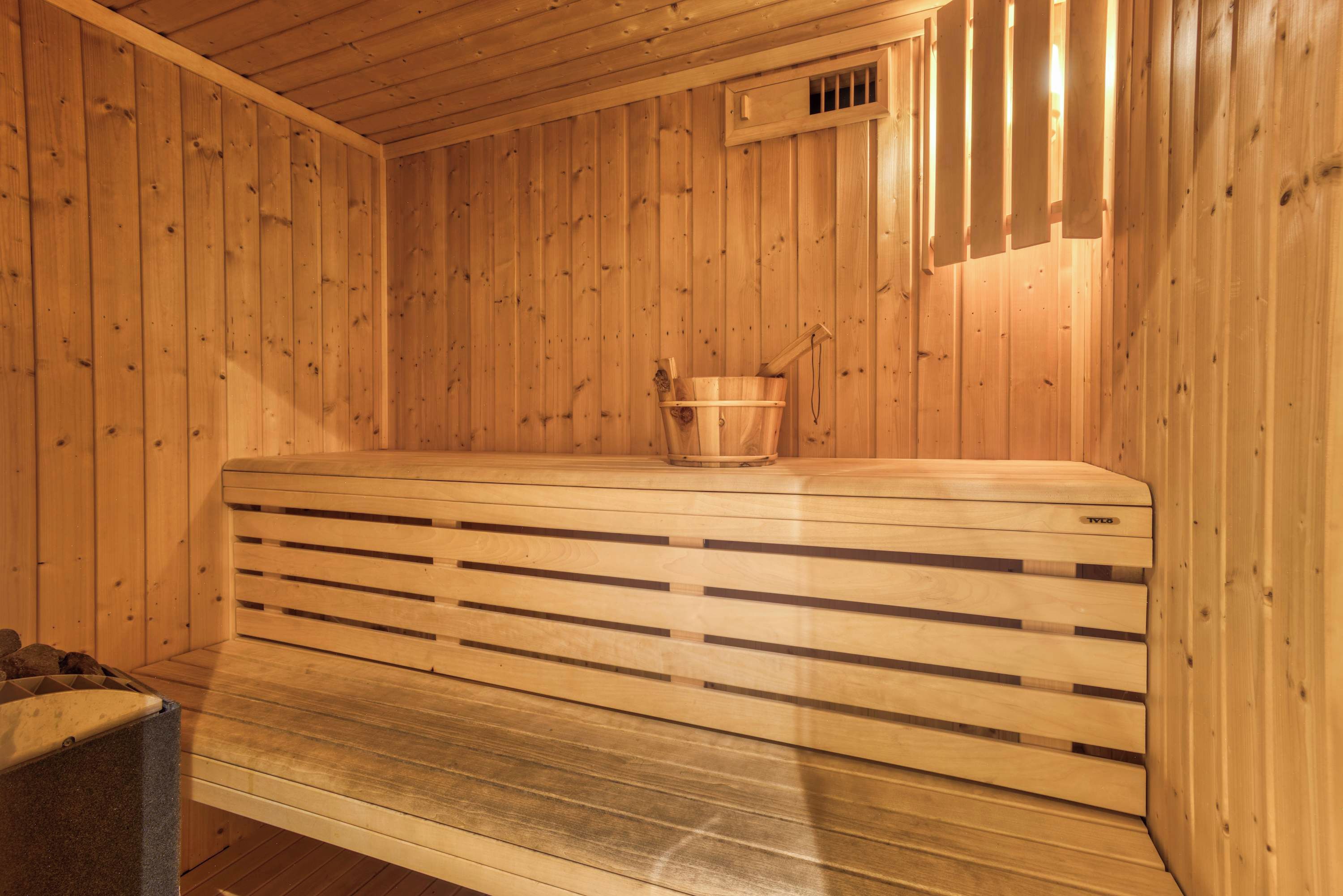 Eine Sauna mit Holzwänden und einer Sitzbank.