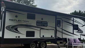 A large RV with the brand name 'Reflection' and 'Grand Design' visible on its side. - Cozy RV in Cool Columbus with AC (Columbus)