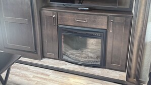 A kitchen with a built-in TV, a microwave, and a grill. - Cozy RV in Cool Columbus with AC (Columbus)